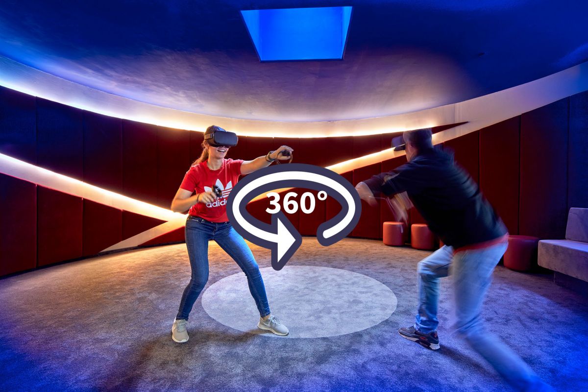 Two people playing with a VR headset, with a circular arrow in the middle with the inscription 