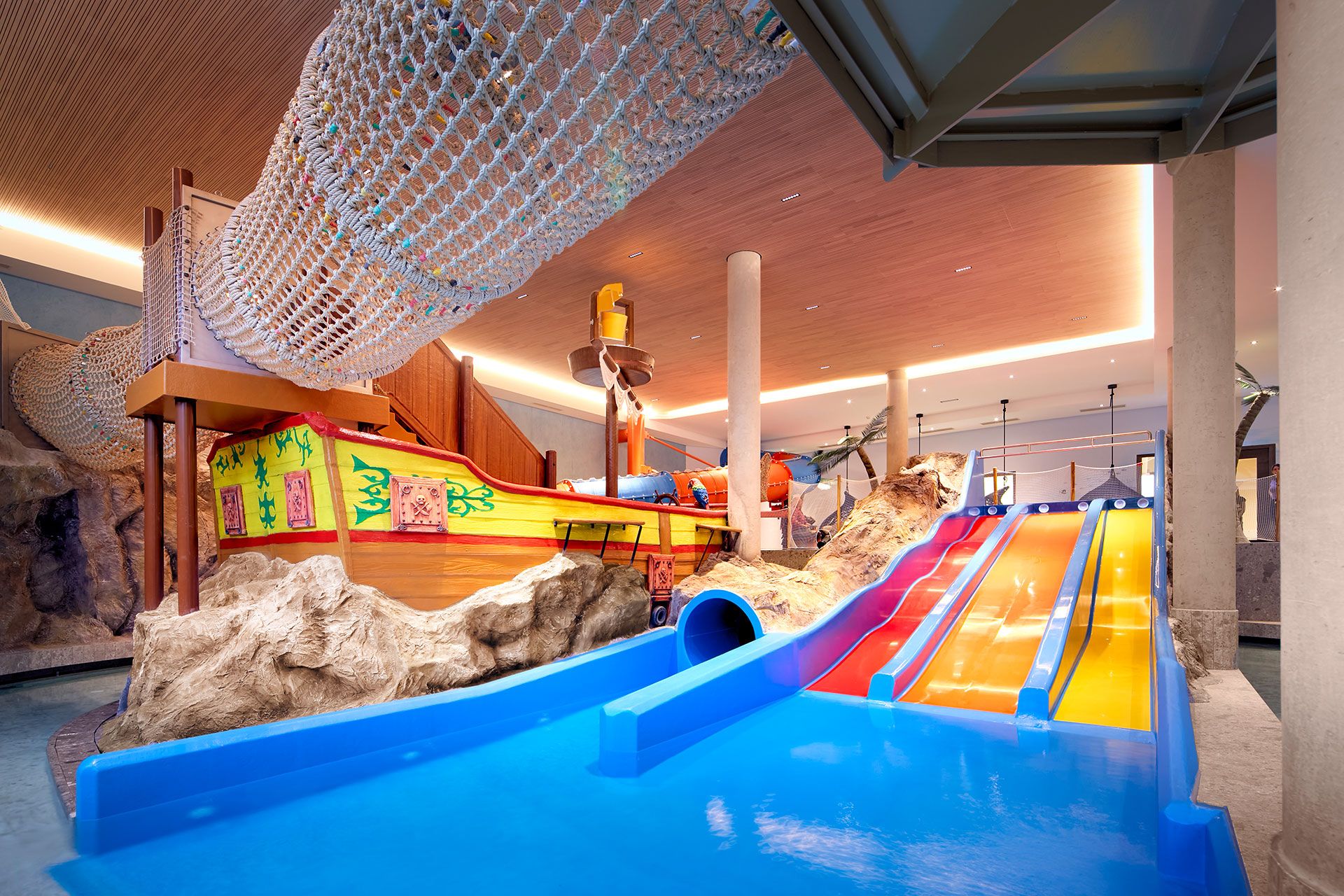 Der Indoor-Kinderpool mit Wasserrutschen, Piratenschiff und weiteren Klettermöglichkeiten. Der Indoor-Kinderpool mit Wasserrutschen, Piratenschiff und weiteren Klettermöglichkeiten.