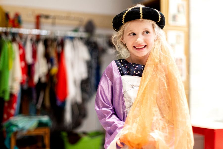 A young girl smiles dressed as a princess into the camera. A young girl smiles dressed as a princess into the camera.