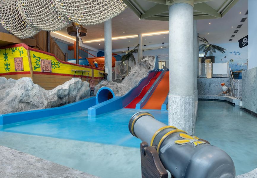 Indoor-Badelandschaft für Kinder mit Wasserrutsche und großem Piratenschiff. Indoor-Badelandschaft für Kinder mit Wasserrutsche und großem Piratenschiff.