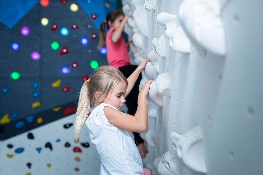 Close-up of a young girl climbing a climbing wall. Close-up of a young girl climbing a climbing wall.