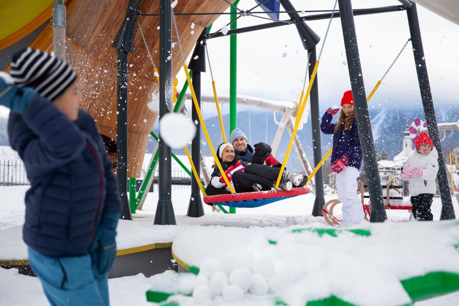 A family on the outdoor playground having a snowball fight. A family on the outdoor playground having a snowball fight.